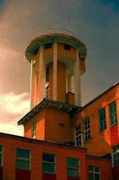 creativo antiguo edificio con un torre en contra el antecedentes de el noche cielo.viejo fábrica foto