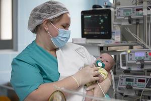 Nurse with a baby in intensive care. Newborn baby in the hospital. photo