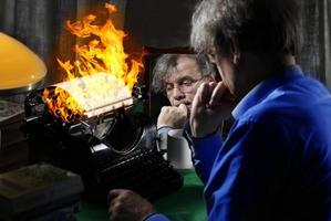 The author writes a book on fire on a printing press. Concept idea for writing a book, writing work, difficulties in writing text. photo