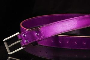 Leather pink belt on a black background. photo
