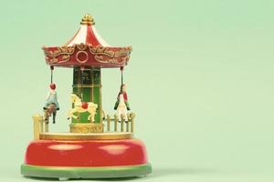 Vintage toy carousel on an emerald background. Red carillon with carousel, retro carousel photo