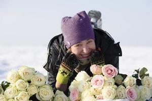 contento mayor mujer con un ramo de flores de flores en invierno. foto