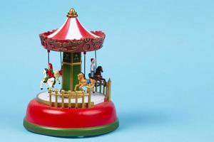 Vintage toy carousel on a blue background. Red carillon with carousel, retro carousel photo