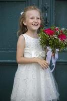 A cute little girl is holding a bouquet of flowers. Women's Day. little girl and flower. Happy child on holiday with flowers. photo