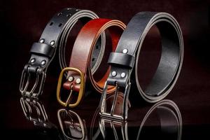 A group of multi-colored leather belts on a black background. photo