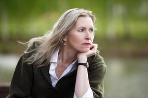 Portrait of a beautiful elderly blonde woman of European appearance. Fifty-year-old woman close-up on a natural background photo