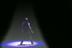 On a dark background, the silhouette of a man who stands in a light circle. The psychological background of choice. photo
