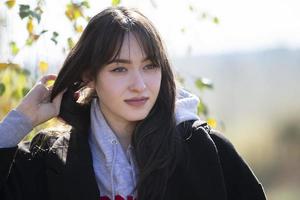 The face of a beautiful young girl who straightens her hair and does not look at the camera.Young woman in everyday life. photo