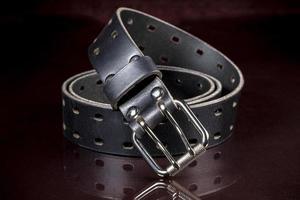 Black leather belt on a dark background. Leather products. photo