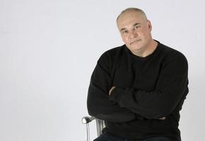 Portrait of a large middle-aged man on a gray background. photo