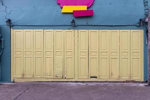 The colorful front door against the bright turquoise building with a sign above it. photo