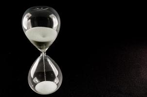 Hourglass on black background photo