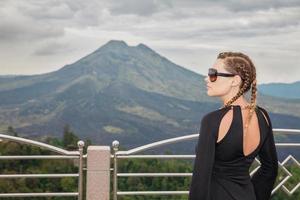 Charming woman against the backdrop of the volcano Batur photo
