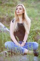 Charming woman posing sitting on a stone photo