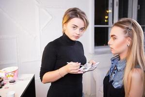 Makeup artist applying make up on nice model photo