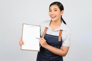 retrato de una joven asiática con uniforme de camarera posa con portapapeles foto