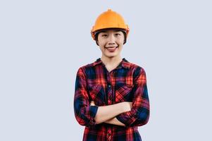 Young female engineer wearing yellow helmet stand with charming smile posture photo