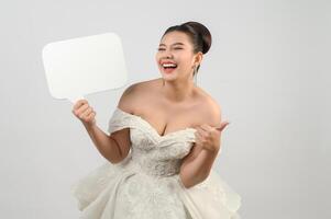 Young asian beautiful bride pose with mockup banner in hand photo