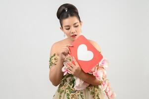 Asian beautiful bride smiling and posing with heart sign on white background photo