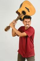 Portrait of Young Asian man in red t-shirt with an acoustic guitar isolated on white background photo