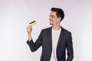retrato de un joven y apuesto hombre de negocios sonriente que muestra una tarjeta de crédito aislada sobre un fondo blanco foto
