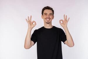 retrato de contento joven hermoso hombre haciendo Okay firmar con mano y dedos terminado blanco antecedentes foto