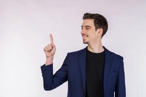Portrait of young businessman pointing fingers at copy space isolated on white studio background photo