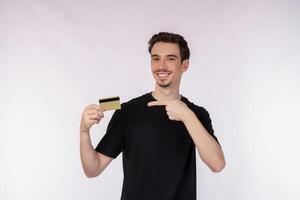 Portrait of Young smiling handsome man in casual clothes showing credit card isolated over white background photo