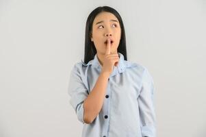 Portrait of Young asian woman in blue shirt thinking and looking up isolated on white background photo