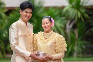 Young couple holding a water bowl on Songkran festival photo