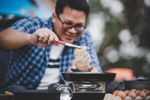 Portrait of Asian traveler man glasses pork steak frying photo