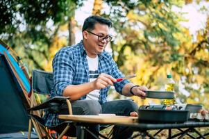 Portrait of Asian traveler man glasses frying a tasty fried egg photo