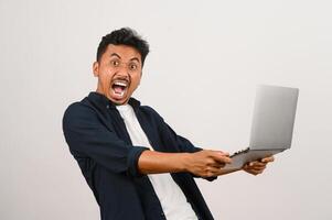 Portrait of shocked asian businessman working on laptop computer isolated over white background photo