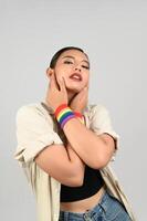 Portrait young asian woman in concept LGBQ with wristband on white background photo