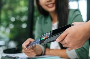 Young businesswoman paying order having contactless payment with cardit card photo