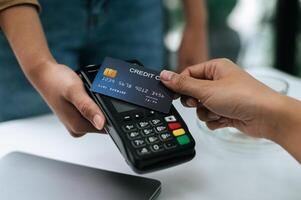 Young woman paying order having contactless payment with cardit card photo