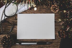 white sheet of paper lying among small decorations on  wooden desk. photo