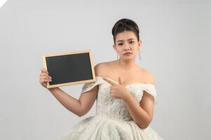 Young asian beautiful bride pose with blank blackboard in hand photo