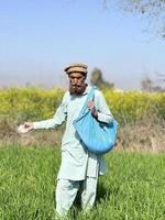 Pakistan farmer spreading fertilizer in the agriculture field photo