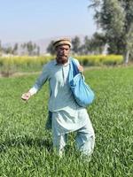 Pakistan farmer spreading fertilizer in the agriculture field photo