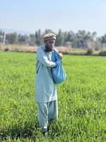 Pakistan farmer spreading fertilizer in the agriculture field photo