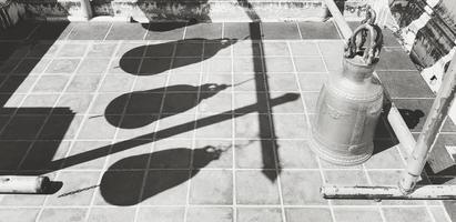 Golden, gray or grey bell put on title floor with light and shadow of other bell in black and white style. Art, object and abstract in monochrome tone photo