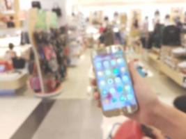 hand holding mobile smart phone in shopping mall,blur background photo