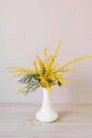 Bouquet of yellow mimosa flowers in a vase. Concept of women's or mother's day photo