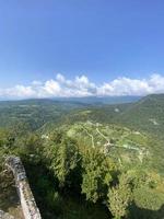 View from the green top of the mountain. Overview of mountains and sky. photo