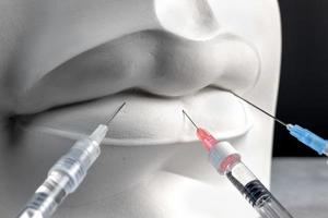 Close up plaster white female lips and medical syringes for botox injection. Creative lip injection concept. photo