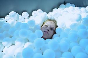 A girl is playing with white balls, a children's playroom photo