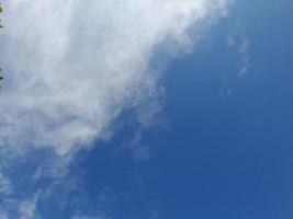 Beautiful white clouds on deep blue sky background. Large bright soft fluffy clouds are cover the entire blue sky. photo