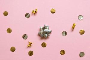 glitter stars and colored confetti flying on pink background photo