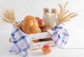 el blanco de madera caja es lleno con tradicional trata para el judío fiesta de shavuot. un ramo de flores de orejas de un pan es un símbolo de el día festivo. foto